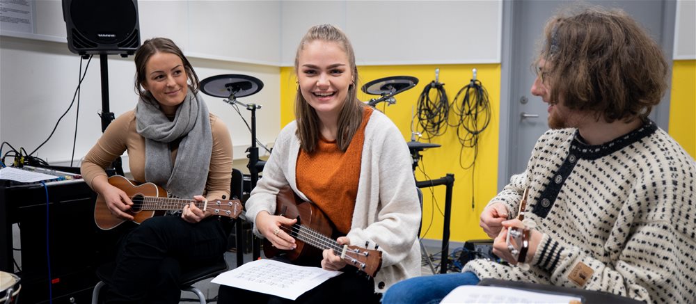 Smilende student med ukulele